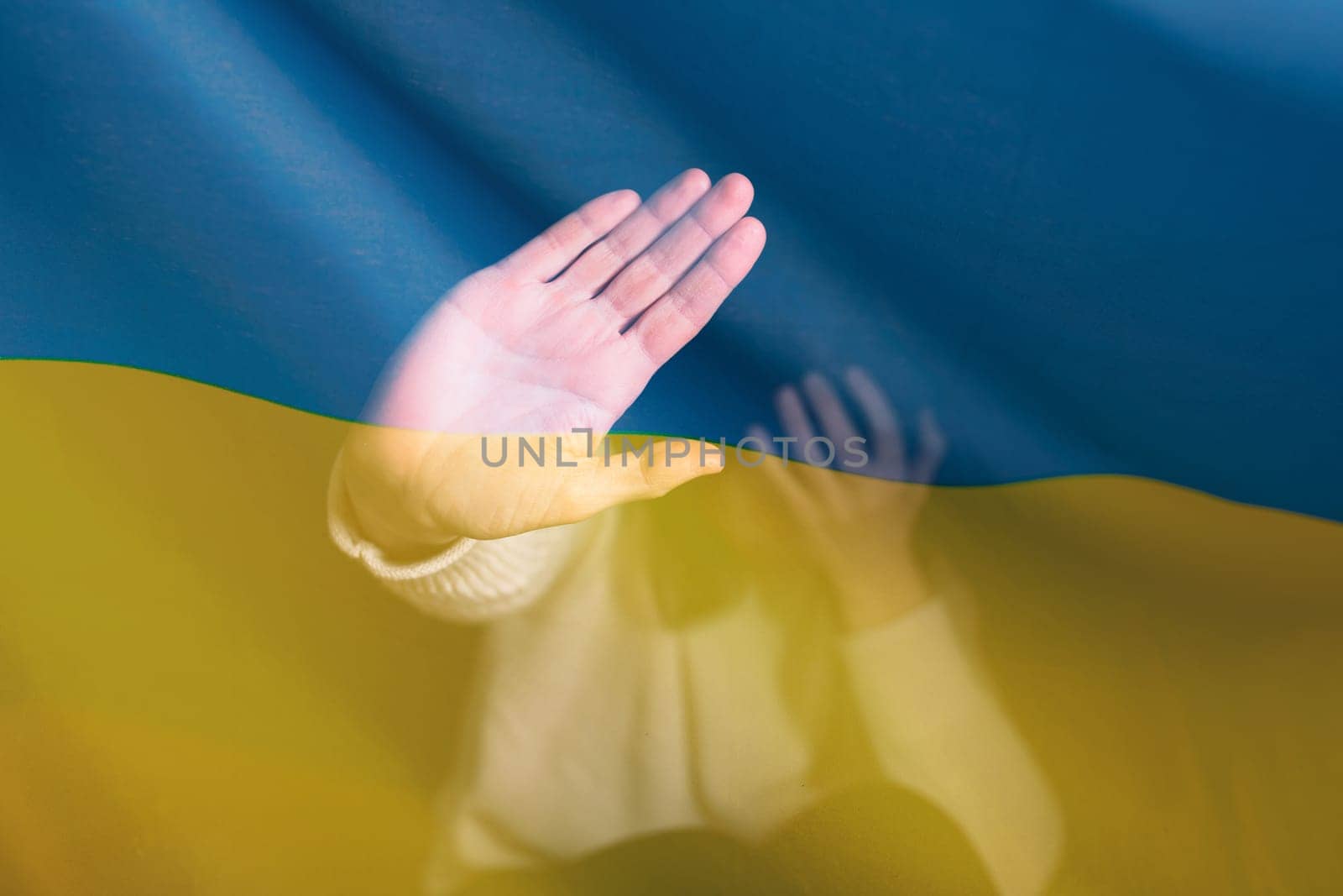 War between Russia and Ukraine. Woman with sad sight, Stop gesture over Ukraine flag.