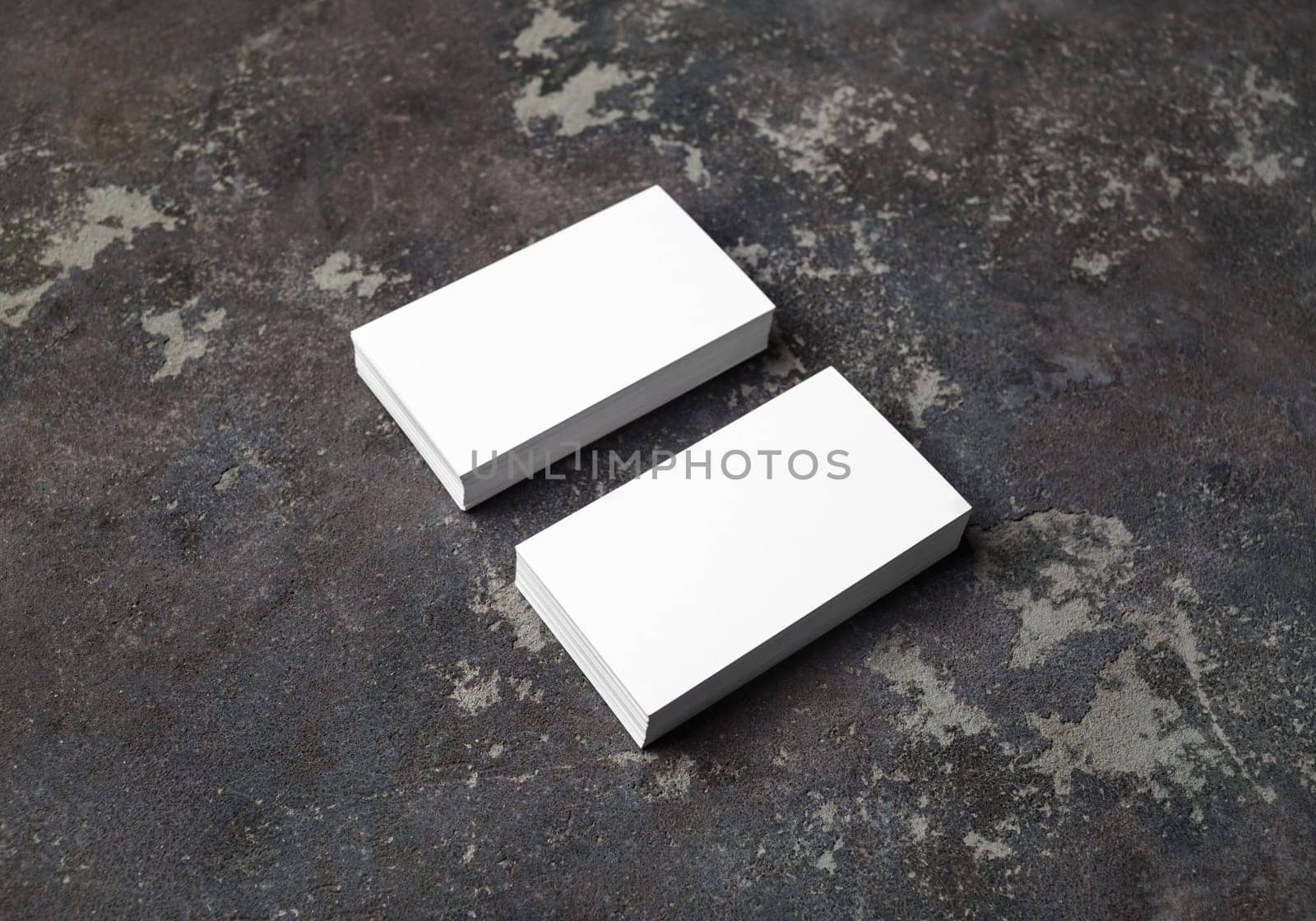 Two stacks of blank business cards on concrete background. Template for your design.