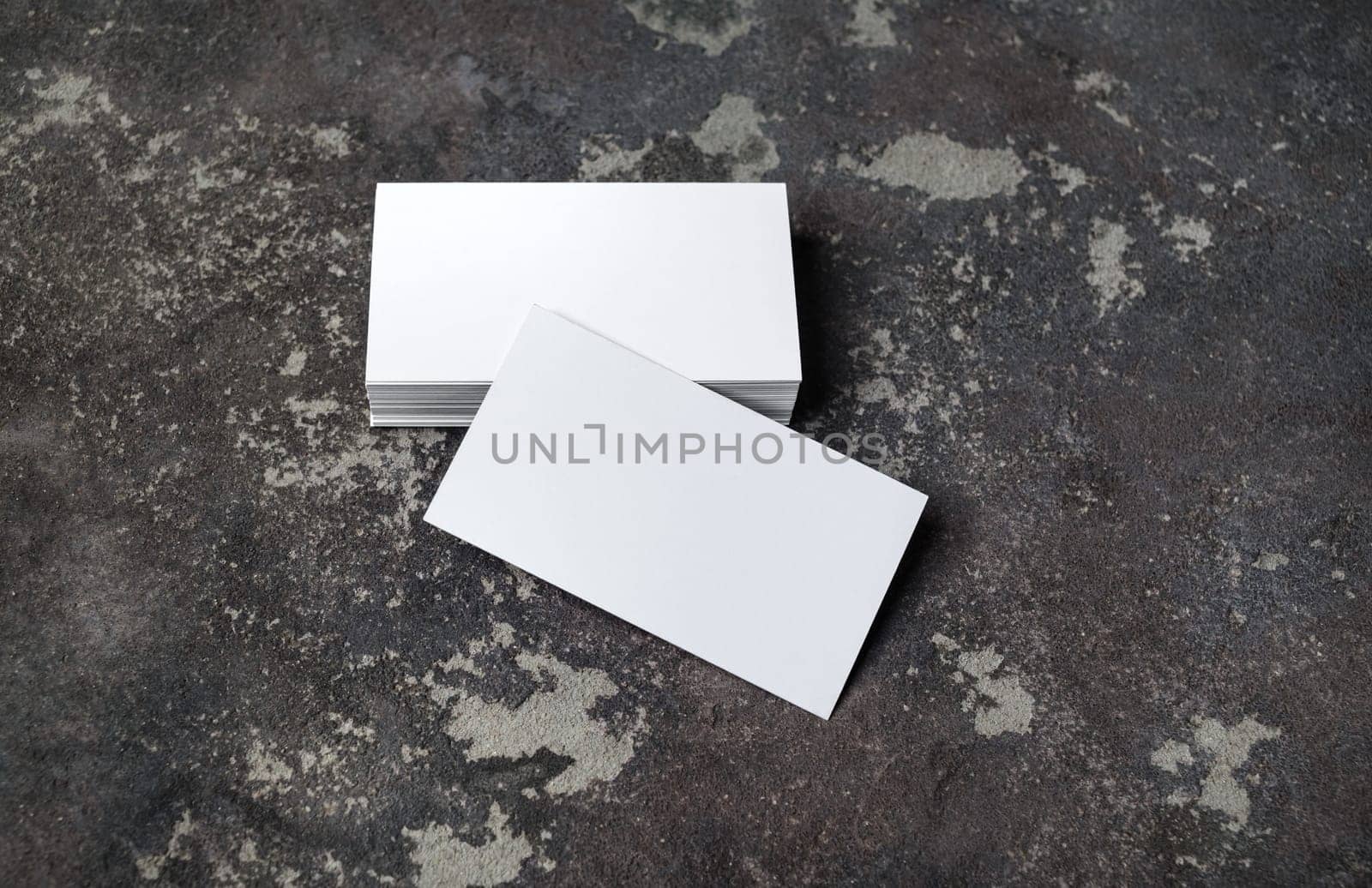 Blank white business cards on concrete background. Mockup for branding identity. Template for graphic designers portfolios.