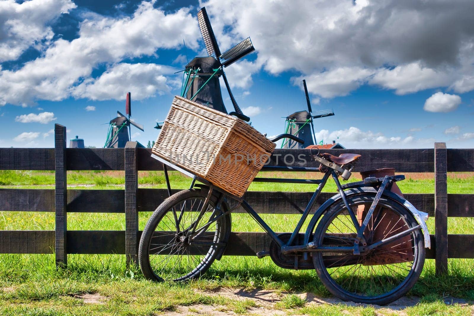 Bicycle with windmill and blue sky background. Scenic countryside landscape close to Amsterdam in Netherlands.