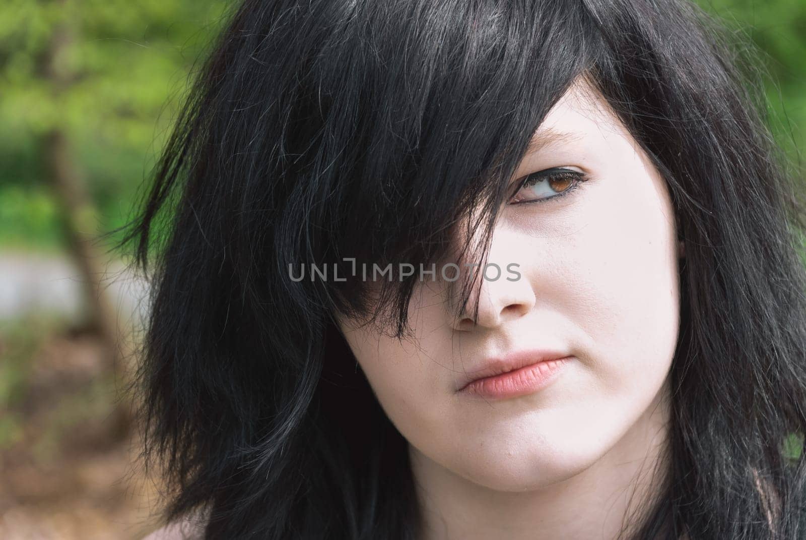 Gothic emo girl looking away, close-up of her face, black hair, horizontal
