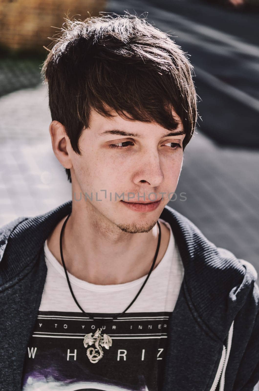 Young adult rock musician, looking away, side view, singer wearing a blue sweatshirt and t-shirt, standing, brown hair and beard