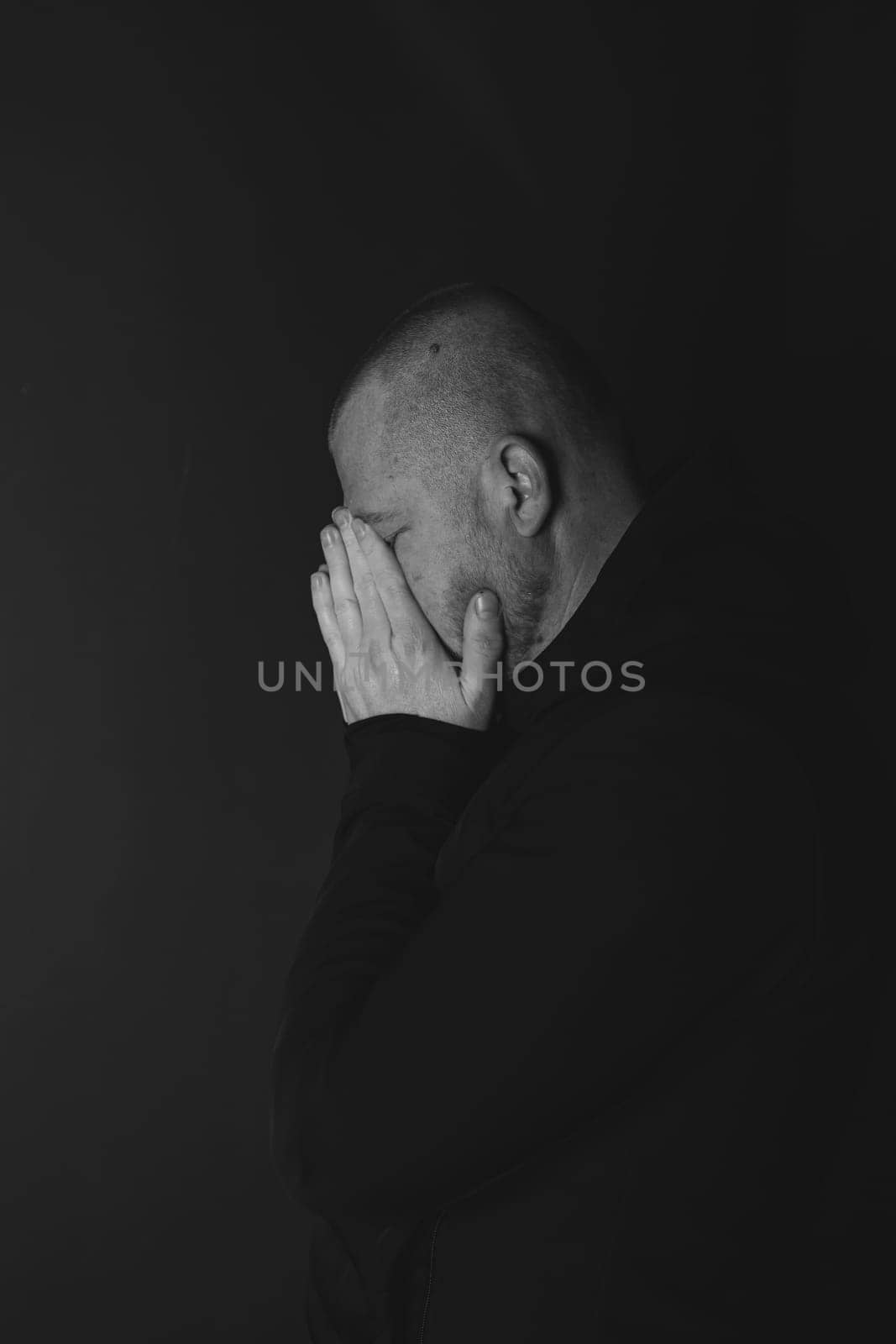 Sad man sitting in dark room. Depression and anxiety concept