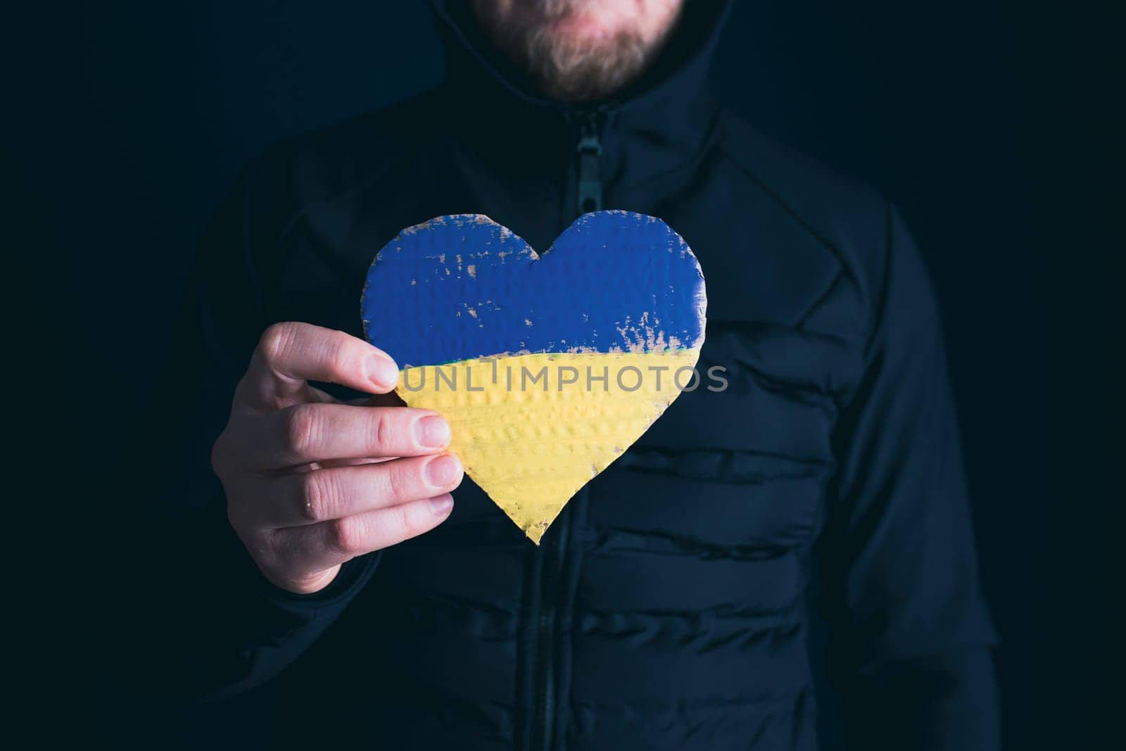 Heart shaped flag of Ukraine in female hands. The concept of solidarity with the citizens of Ukraine.