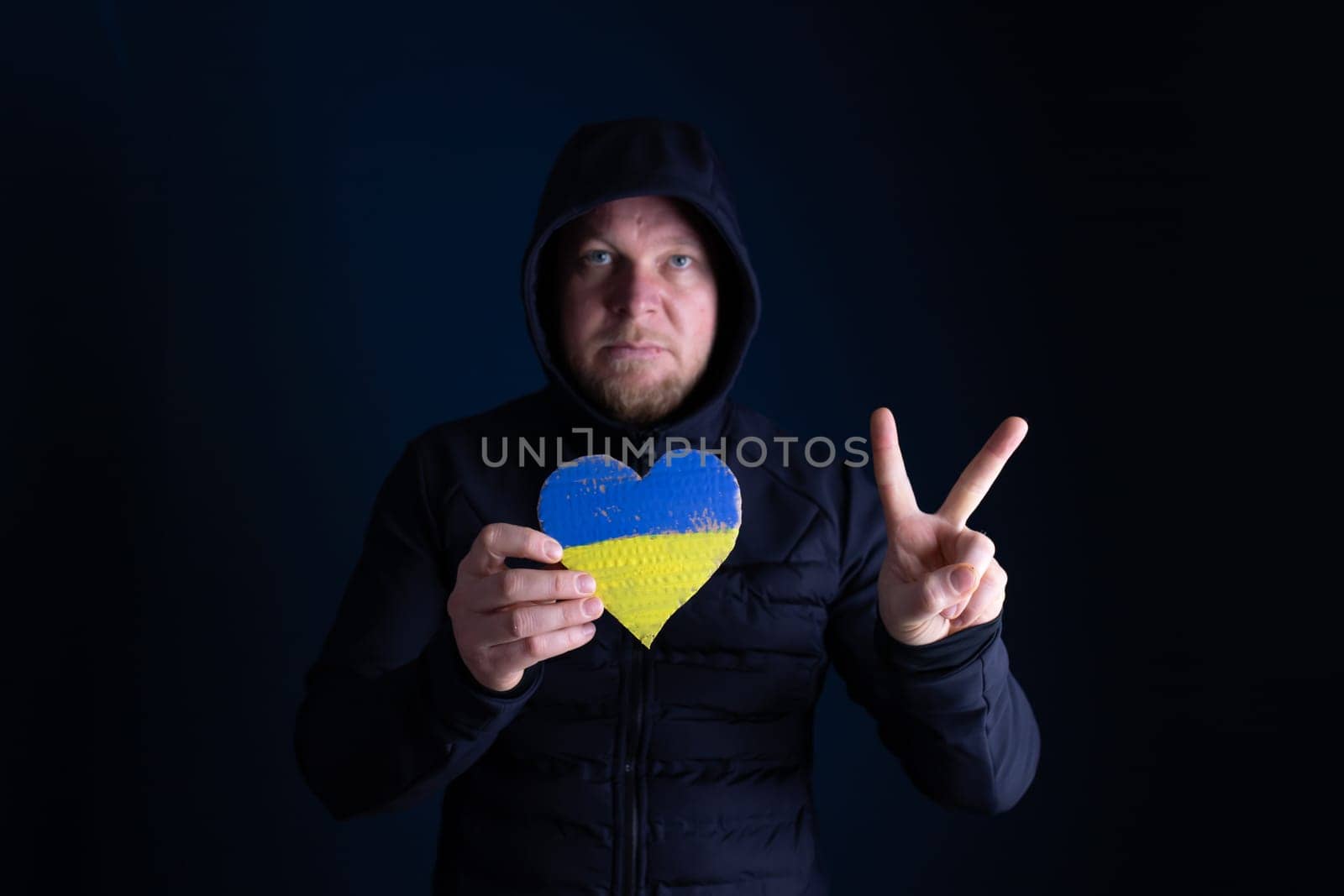 Heart shaped flag of Ukraine in female hands. The concept of solidarity with the citizens of Ukraine.