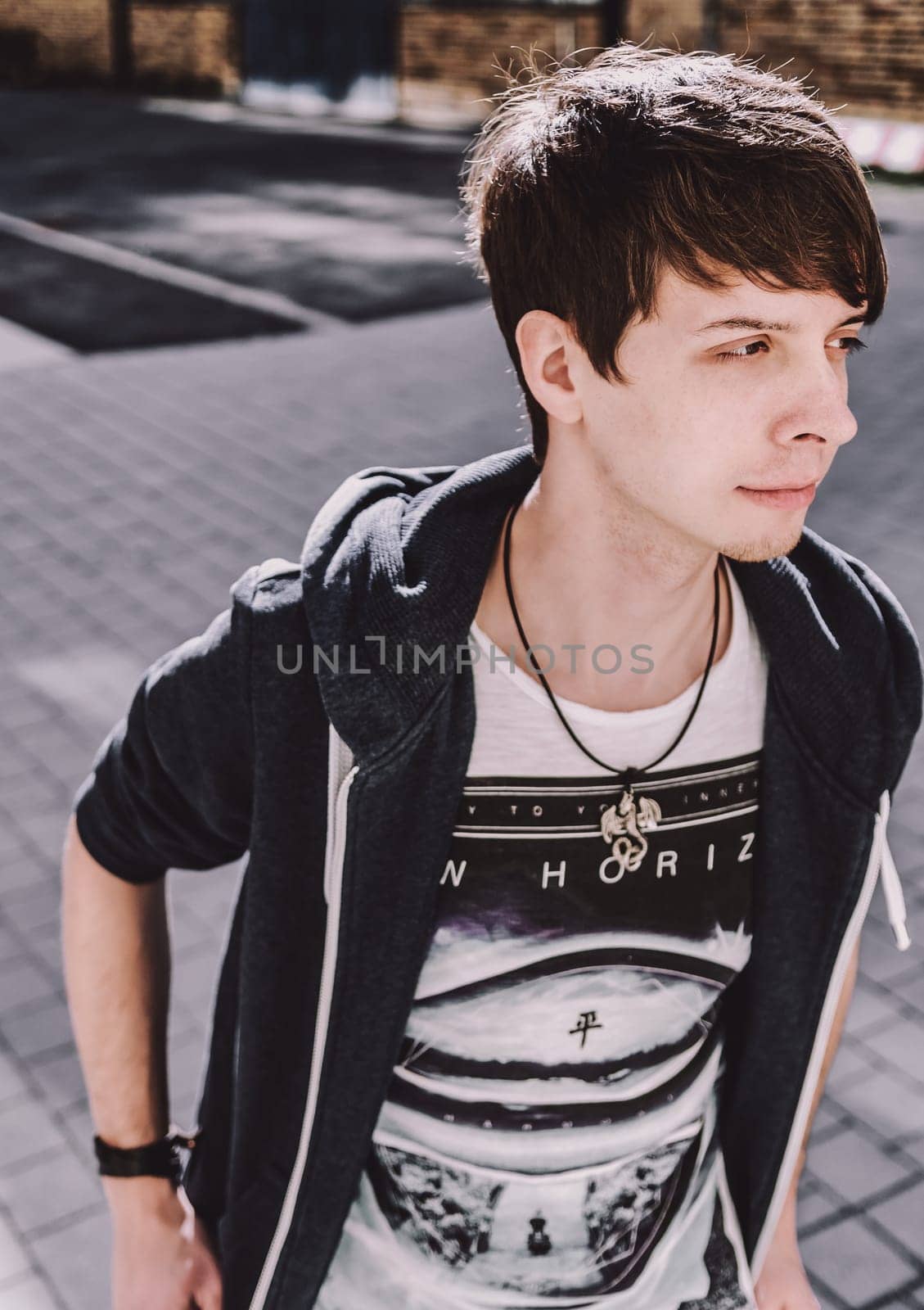 Young adult rock musician, looking away, side view, singer wearing a blue sweatshirt and t-shirt, standing, brown hair and beard