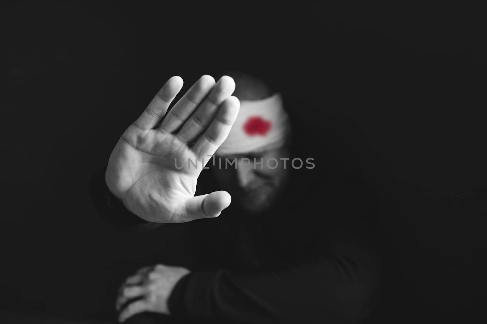 Wounded man showing stop gesture. Stop war, russian aggression, freedom to Ukraine concept.