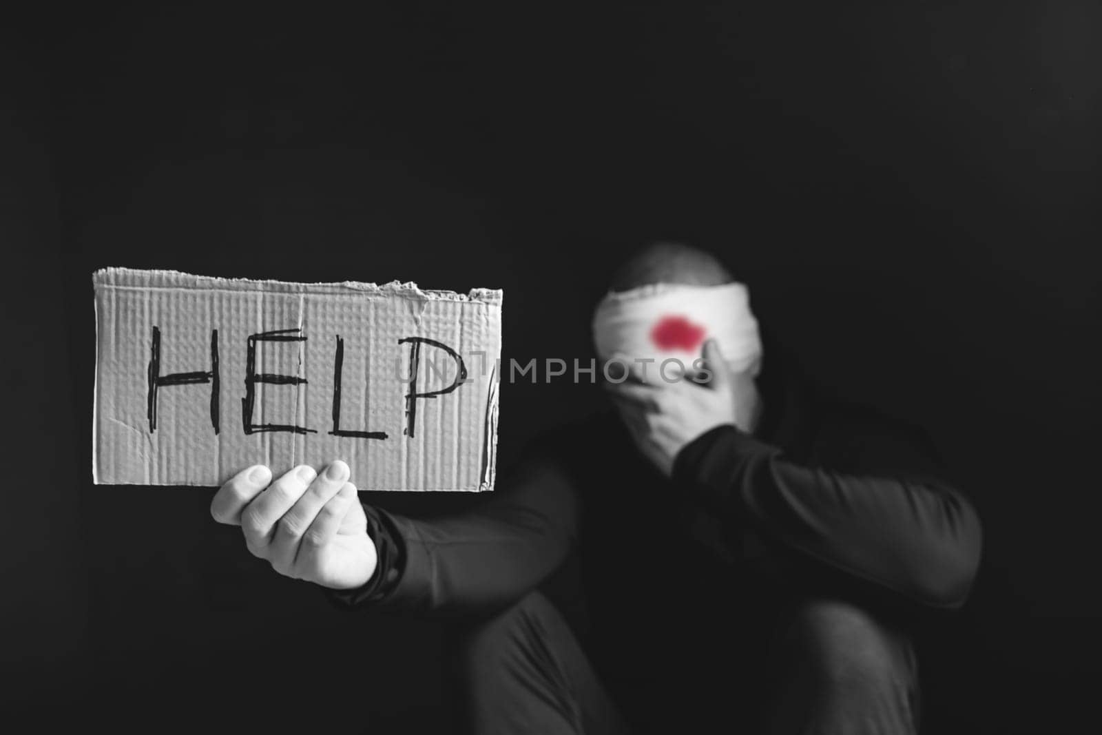 Wounded man holding placard with Help text. Stop war, russian aggression, freedom to Ukraine concept.