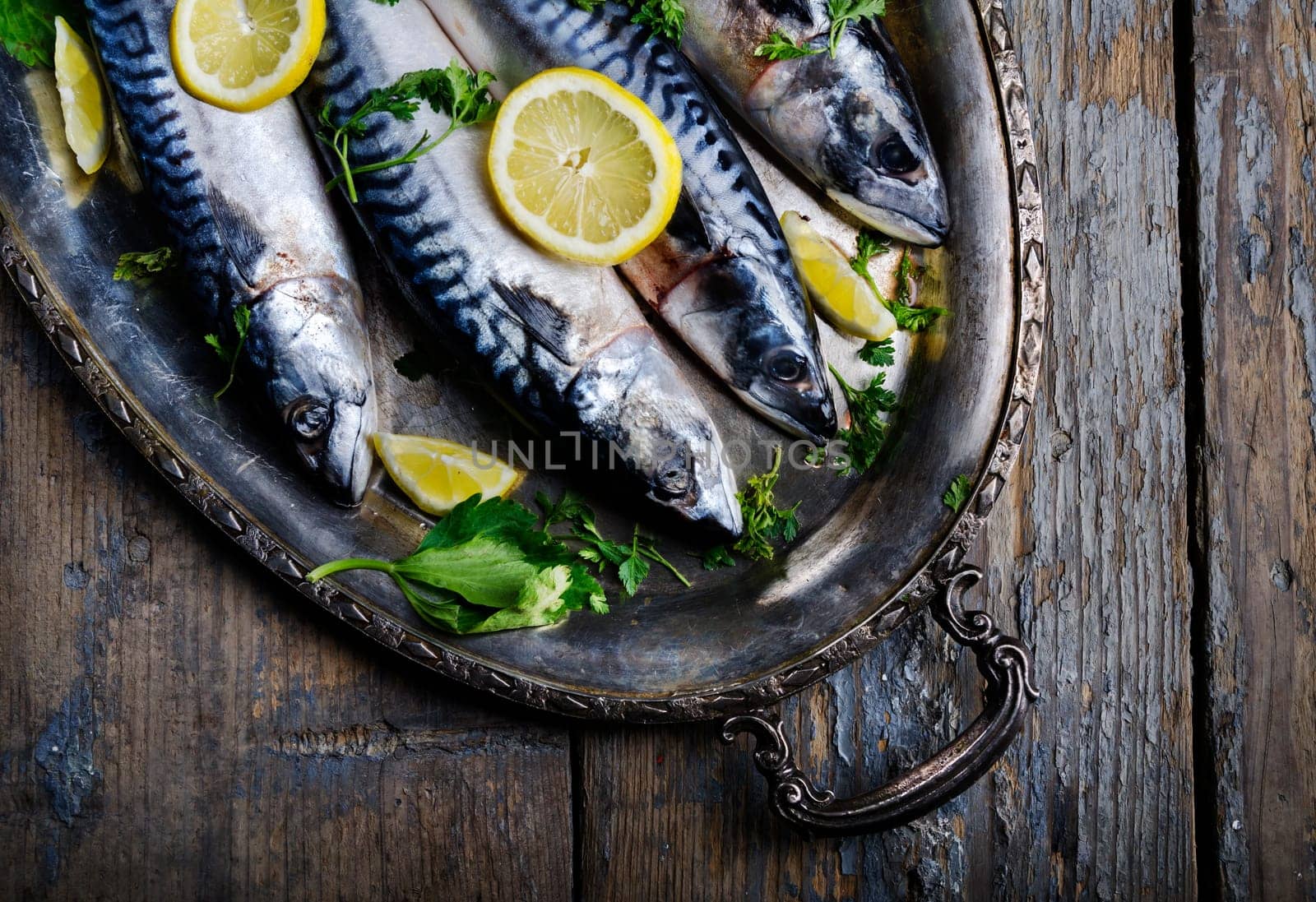 Mackerels seved on silver plate with lemon