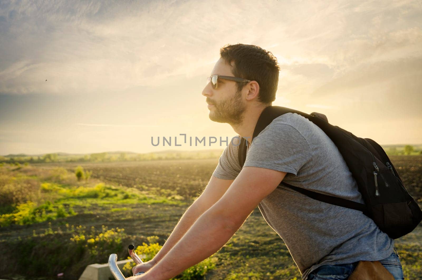 Man riding a bicycle in nature at sunset