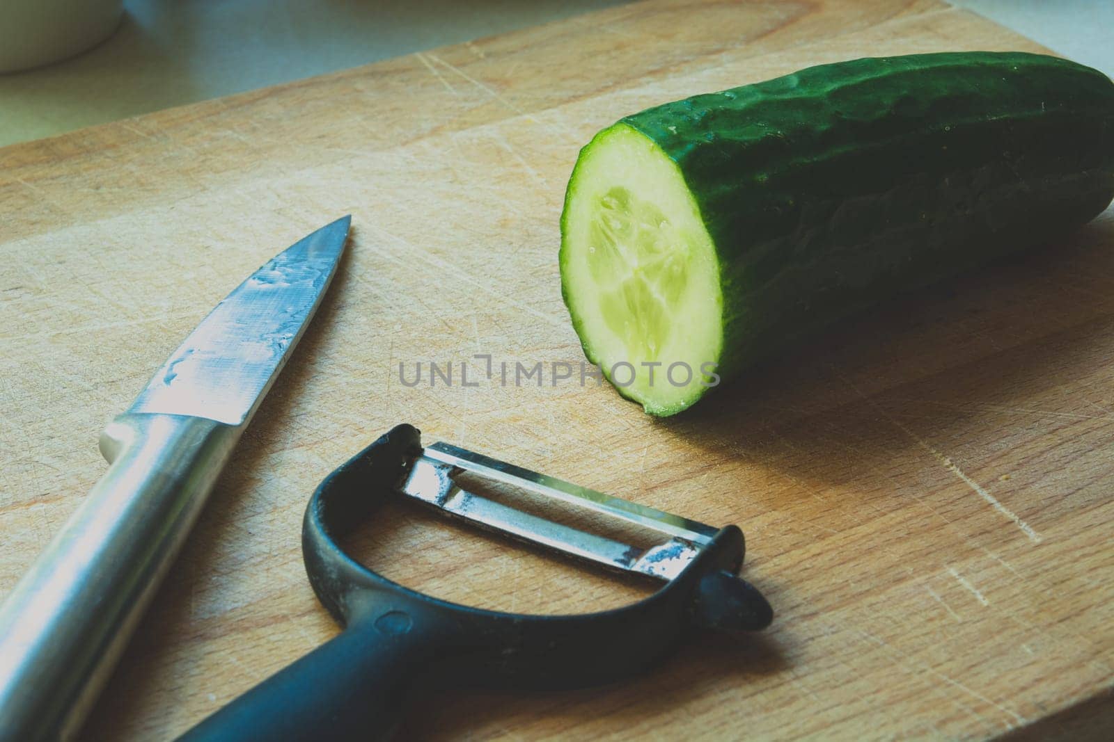 A simple knife or a green cucumber peeler