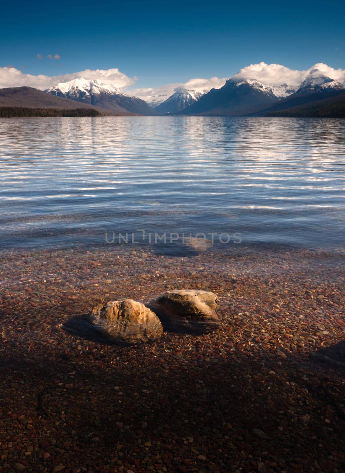 The sun shows through the clear water at Lake McDonald in Montana