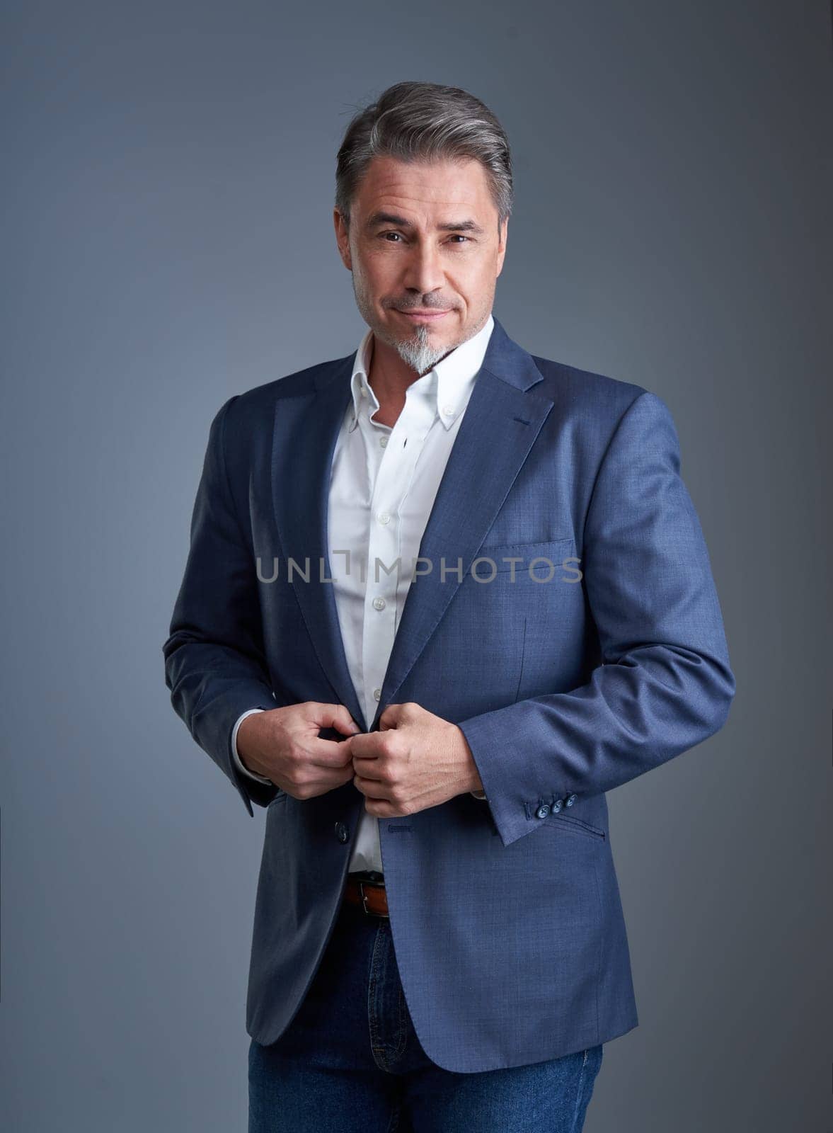 Business portrait of older businessman against gray background.