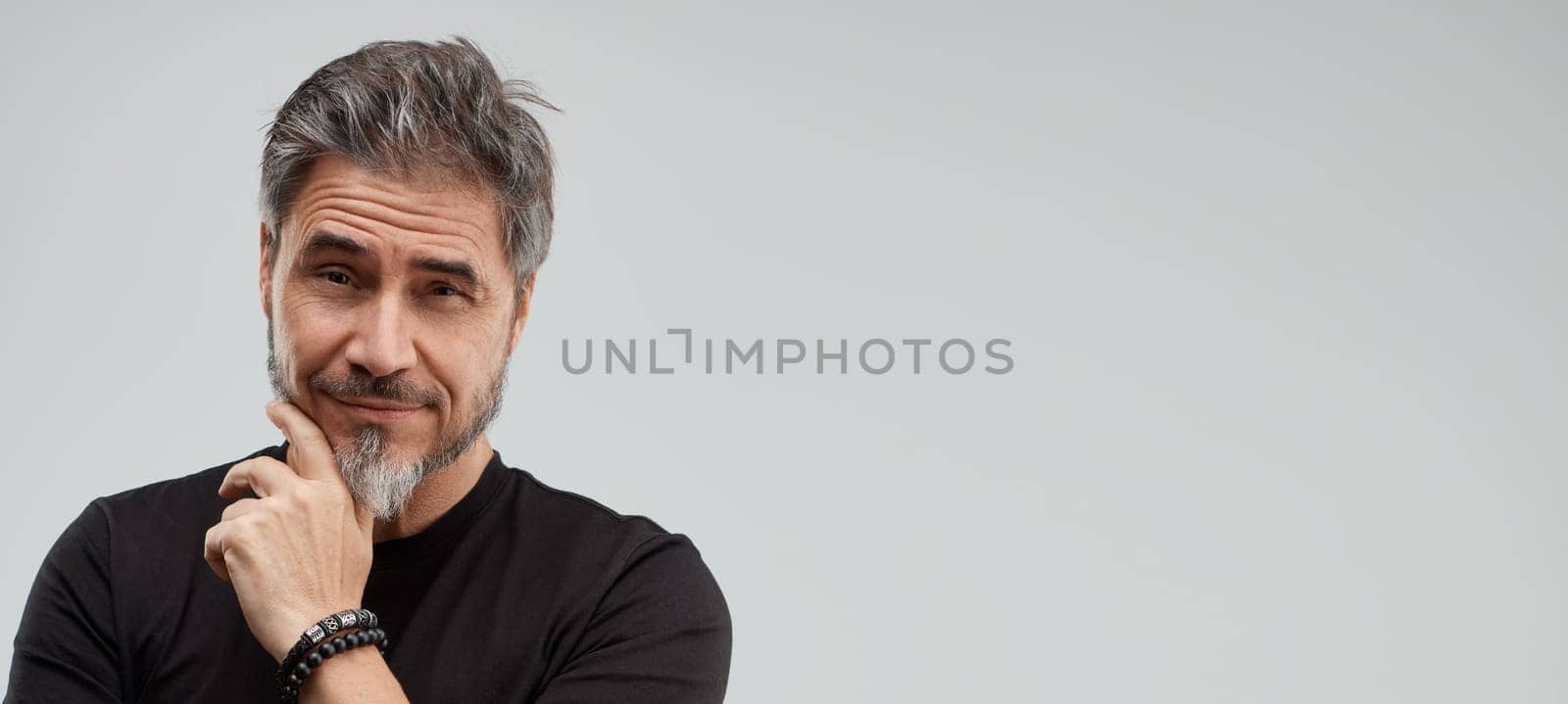 Portrait of happy older white man, beard gray hair, smiling. Gray background, wide banner, copy space.