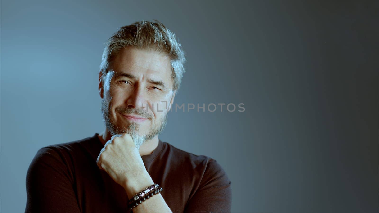Portrait of happy older white man on gray background, smiling, copy space.