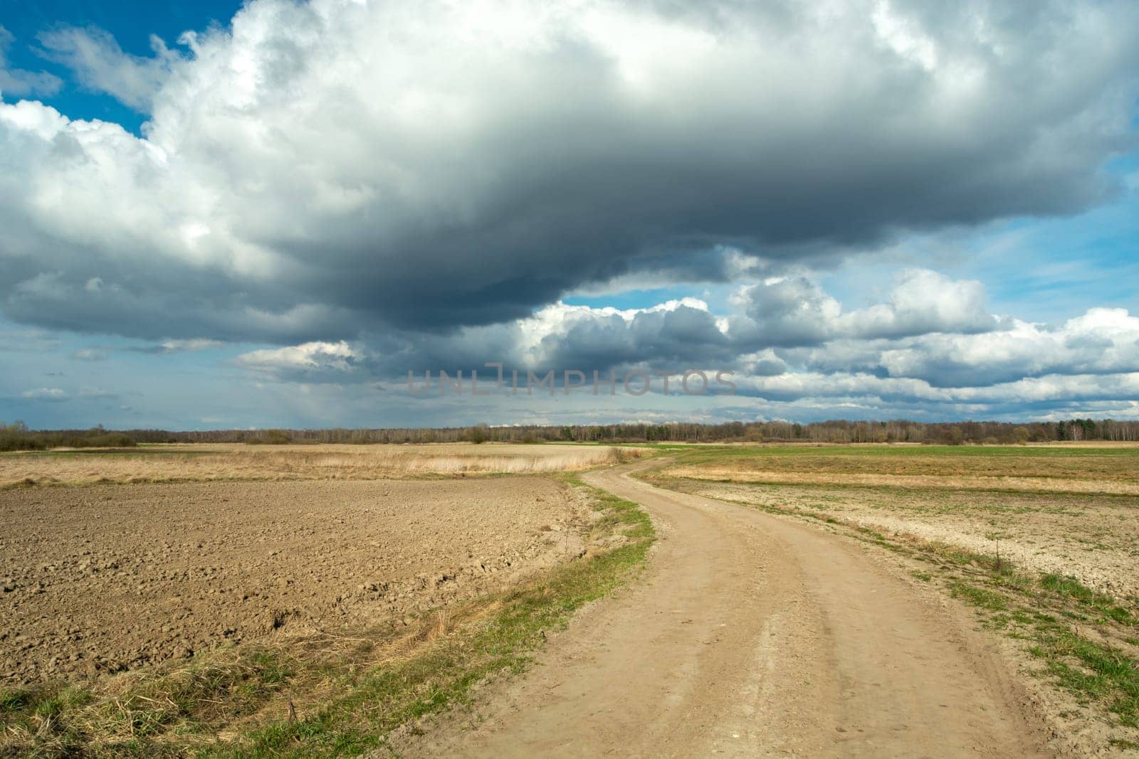 A sandy road through the fields and clouds on the sky, Czulczyce, Poland