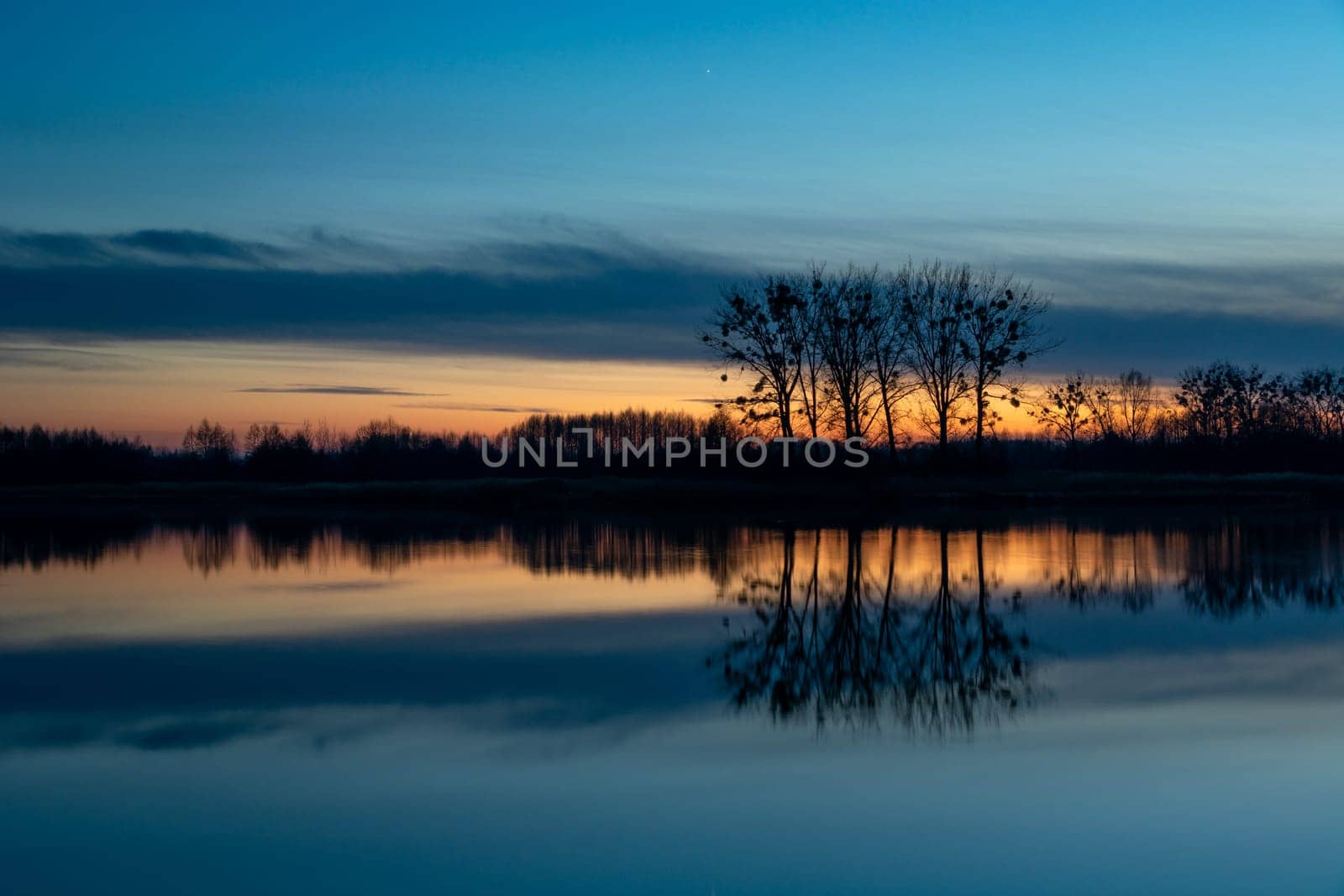 Reflection of trees in the water after sunset, Stankow, Poland