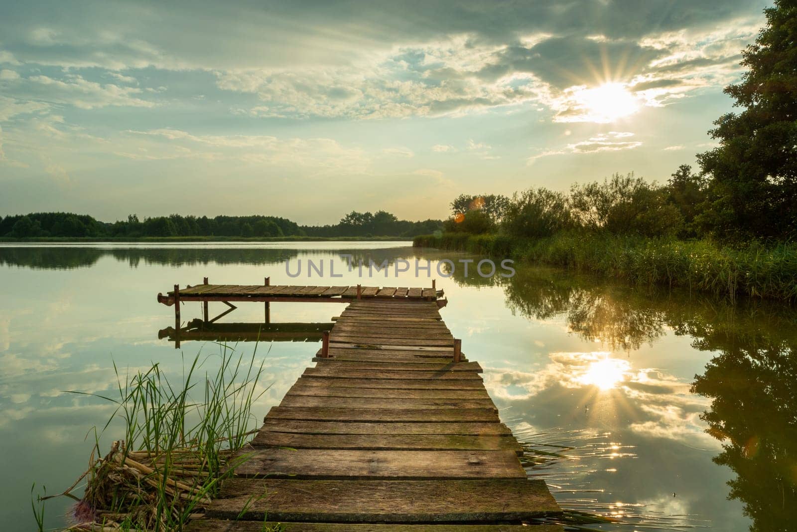 Sunlight reflecting on the lake with a pier, Stankow, Poland