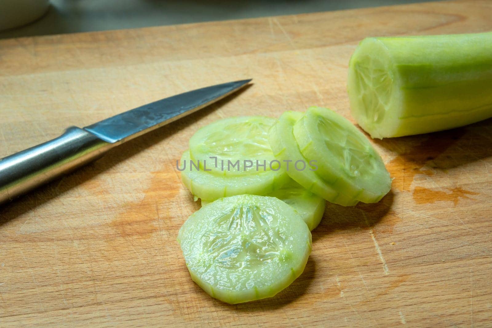 Peeled green cucumber, sliced with a silver knife
