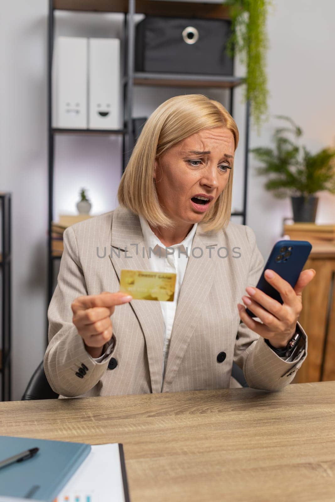 Angry mad stressed freelancer try to pay online shopping with blocked credit card smartphone. Annoyed mature businesswoman girl buying bank refuse problem unsuccessful payment lack of money balance.