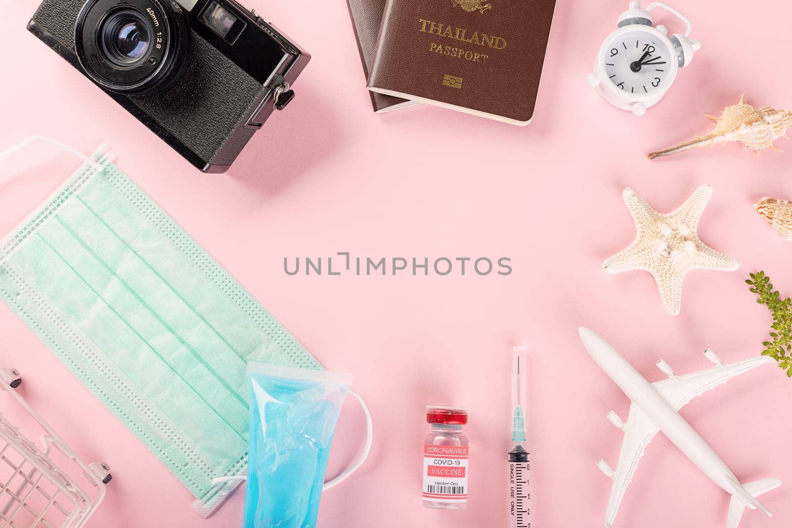 World Tourism Day, Top view model plane, medical face mask, coronavirus vaccine and vintage camera, Holiday accessory beach trip travel vacation studio shot isolated pink background with copy space