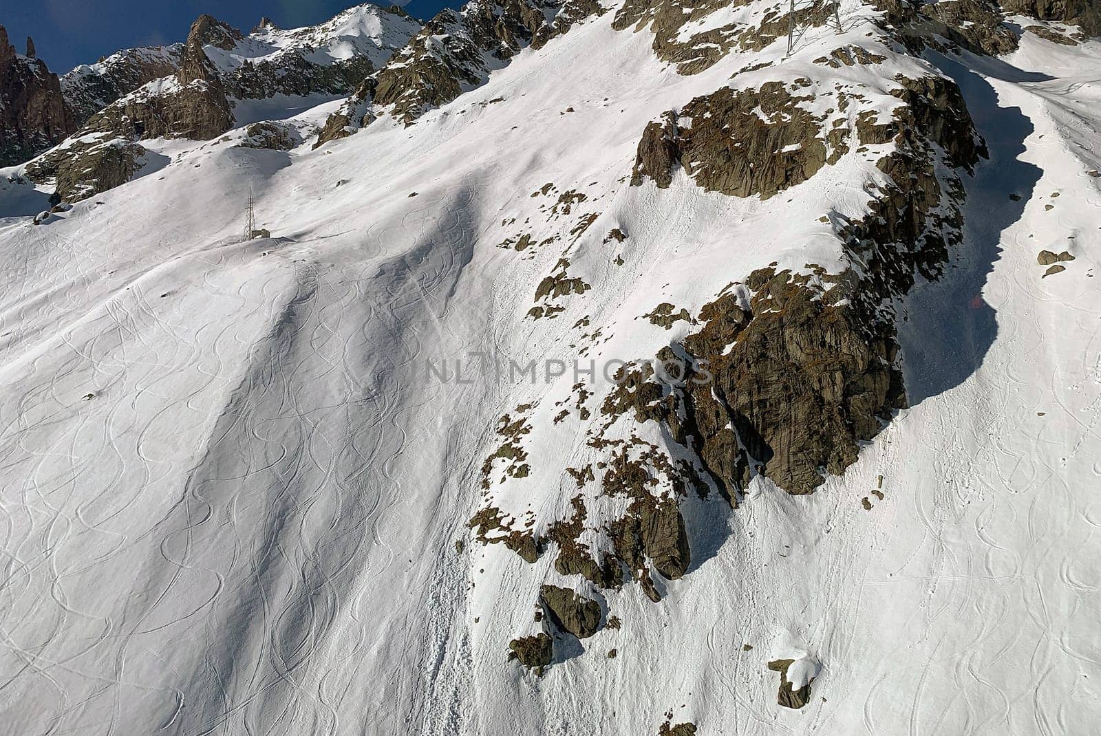 Ski run along the slope in the Mont Blanc massif in the italian Alps at Courmayeur town, Italy. The Alps are the highest mountain range system in Europe