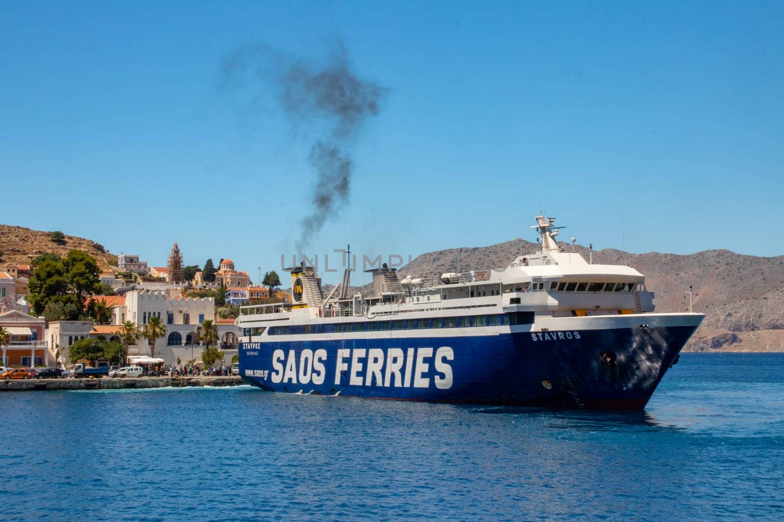 SYMI, Greece - JUN 03, 2021. A large ferry docking in the pictorial harbour on the Greek island of Symi island in Greece. Dodecanese.