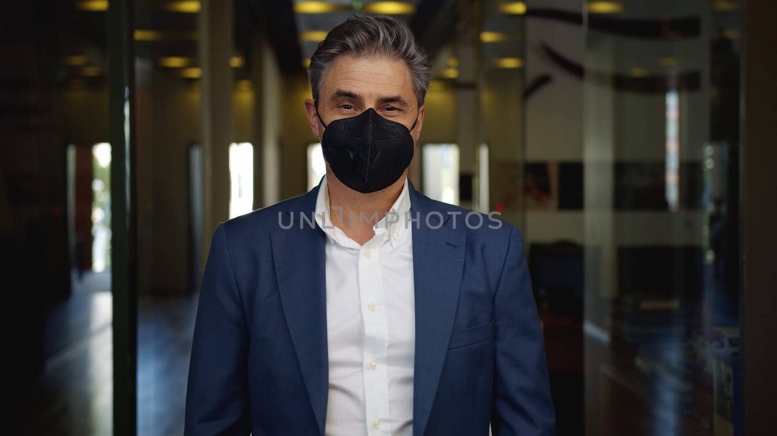 Coronavirus - businessman wearing face mask in empty office. Business in coronavirus Covid-19 quarantine times.