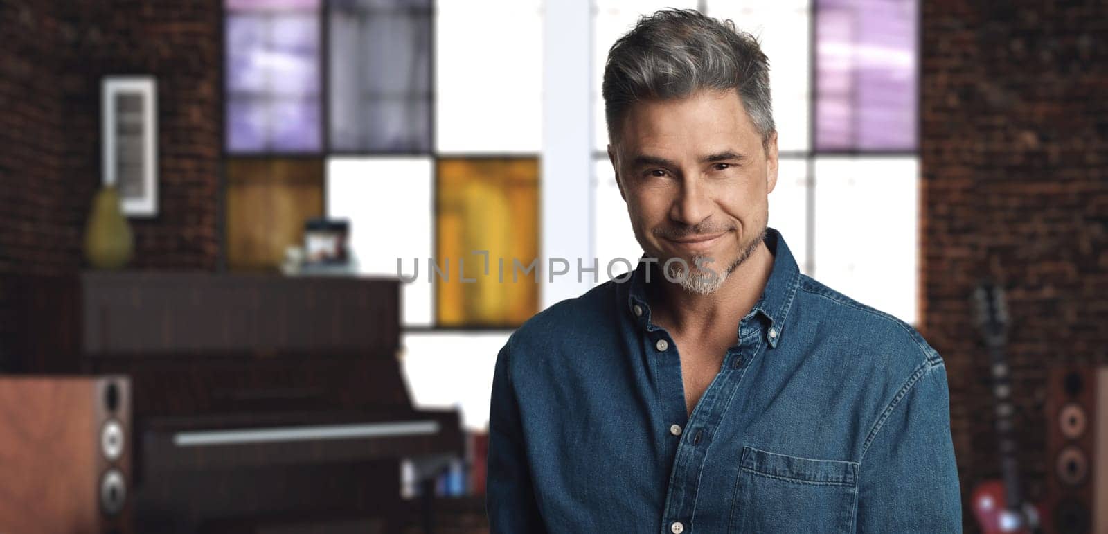 Portrait of casual older man - musician at home smiling.