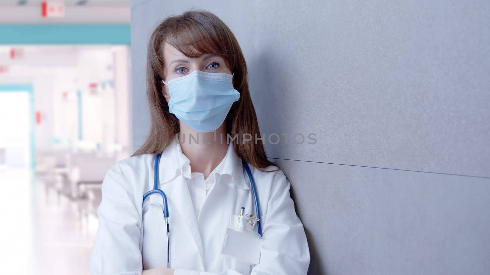 Covid-19 - Smiling female doctor in glasses on hospital corridor, Confident young woman.