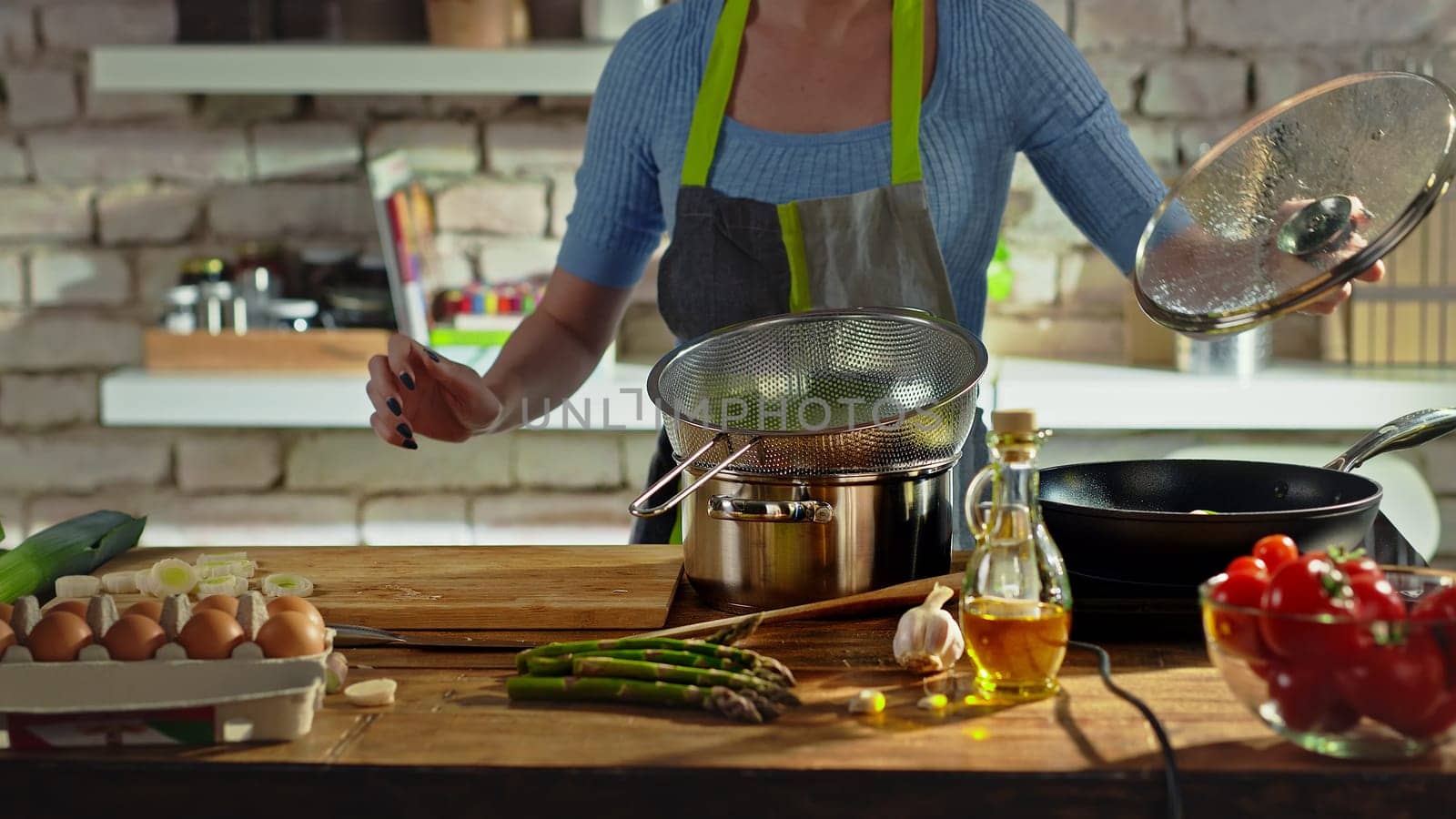 Woman cooking in kitchen. Real people, authentic, no face.