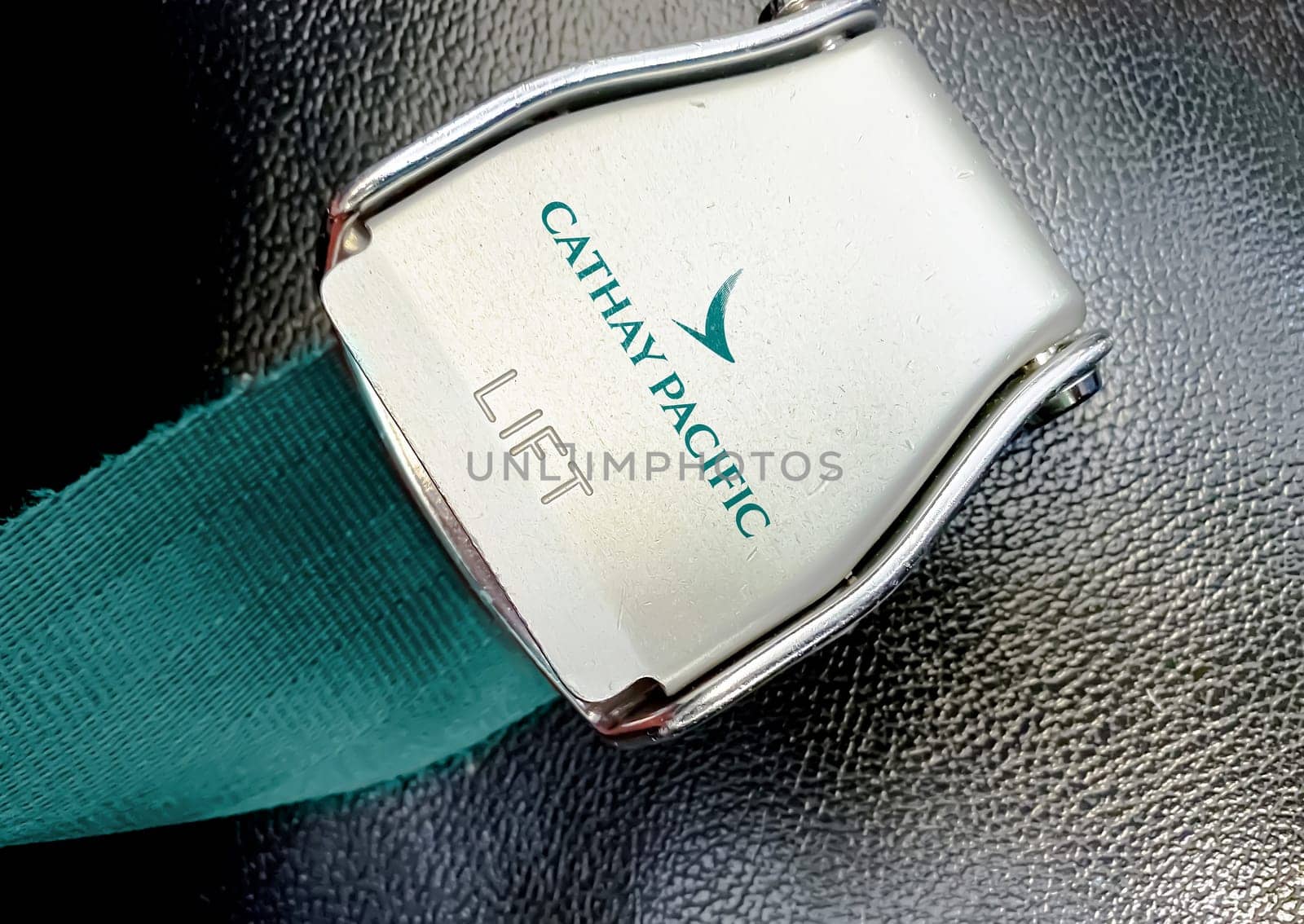 Hong Kong, CHN, July 2019: green lap belt of an empty seat inside an airplane with the Cathay Pacific airlines logo printed on the metal. Cathay Pacific is the flag carrier airline of Hong Kong.