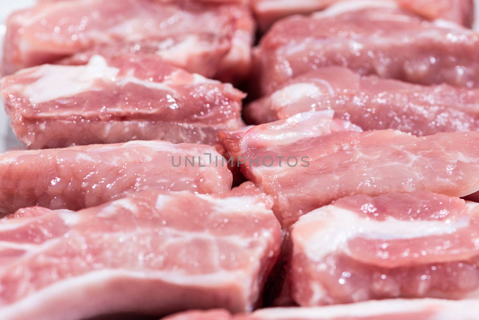 Close up top view pack pieces raw meat of pork loin on bone, fresh red pork with white fat of pork rib, Cut into pieces and put them in a row