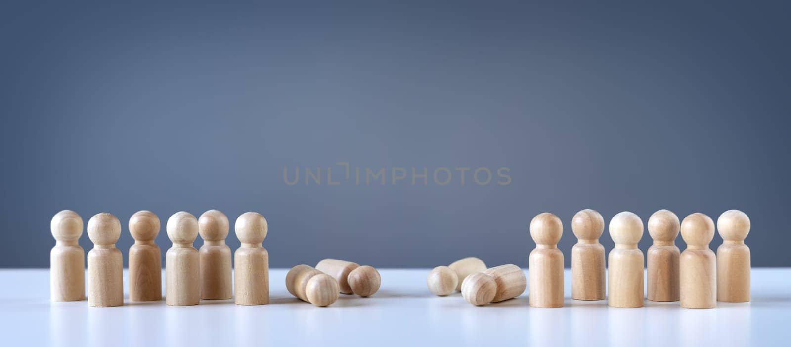 Abstract photography with figurines of wooden men on the grey background. Concept of the military attack, war, demonstration and confrontation.