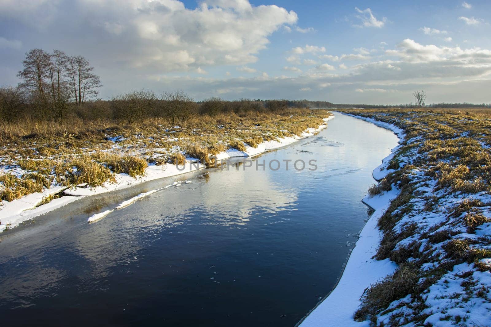 Uherka river, snow and clouds on the sky, Czulczyce, Poland