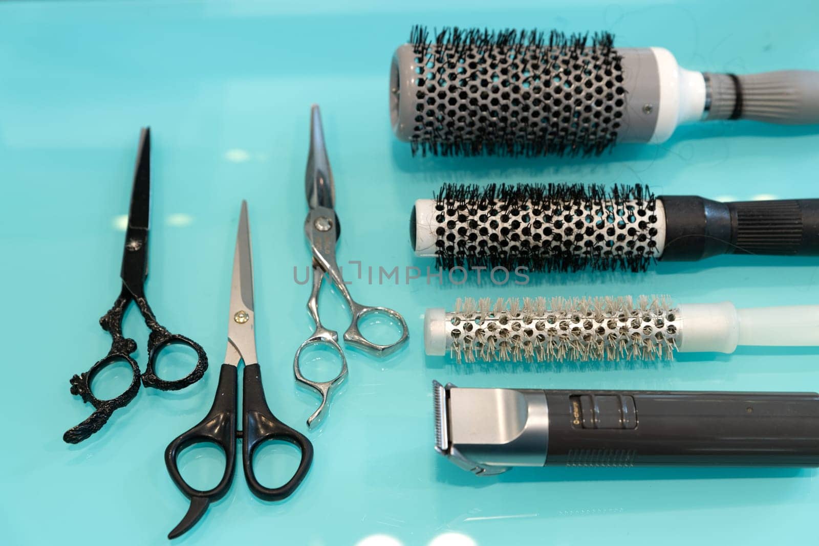 Hairdresser tools on modern background with copy space in center.
