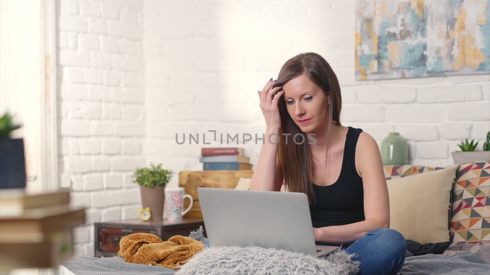 Stay at home and work in home office - Casual woman sitting on bed working online from home with laptop computer.