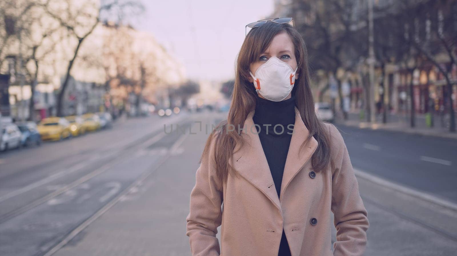 Covid-19 coronavirus protection - Woman in protective face mask in an empty european city.