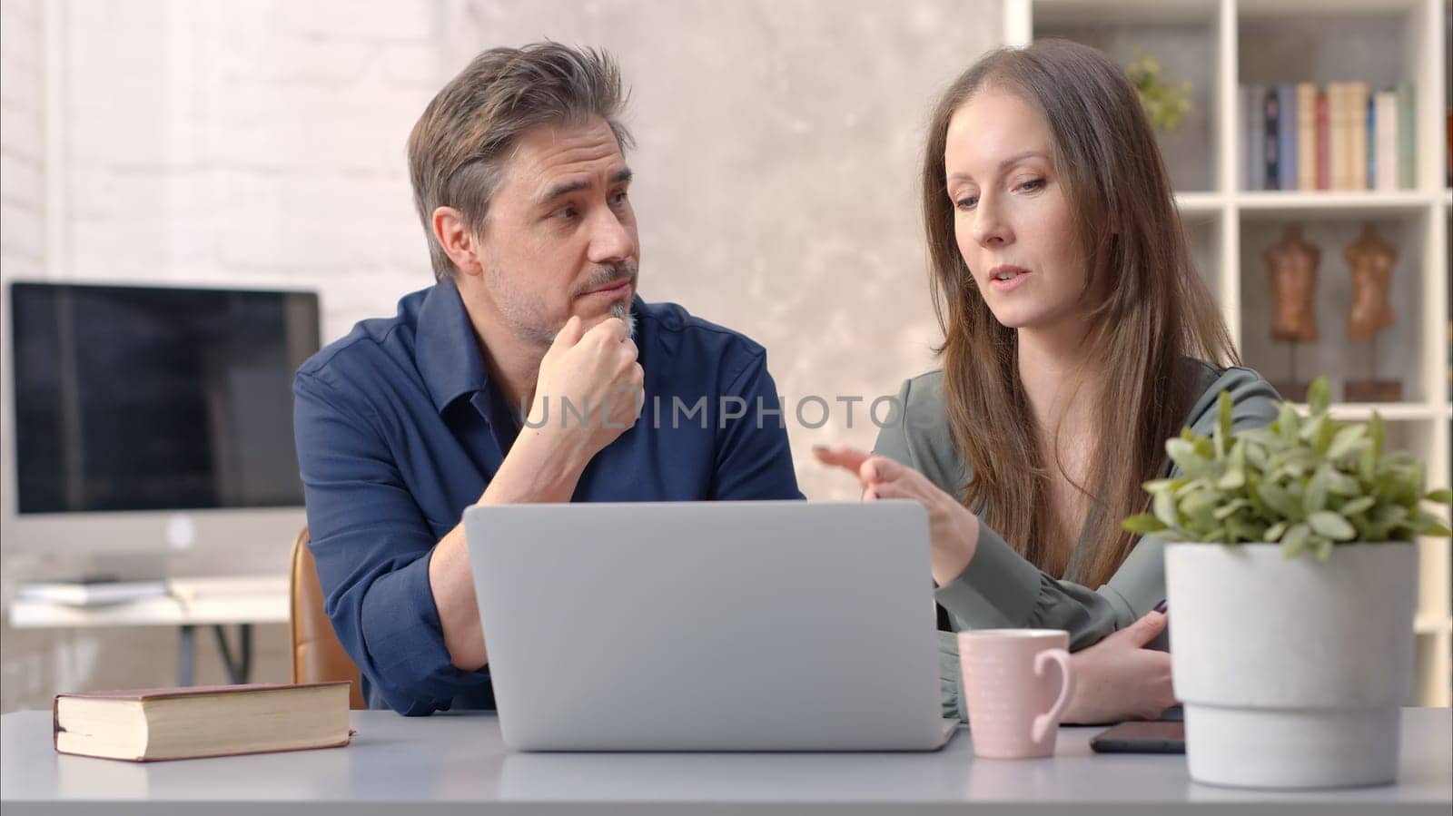 Business people working in office with laptop computer. Happy couple working from home at desk. Talking, meeting, cooperation, entrepreneurs, advisor.