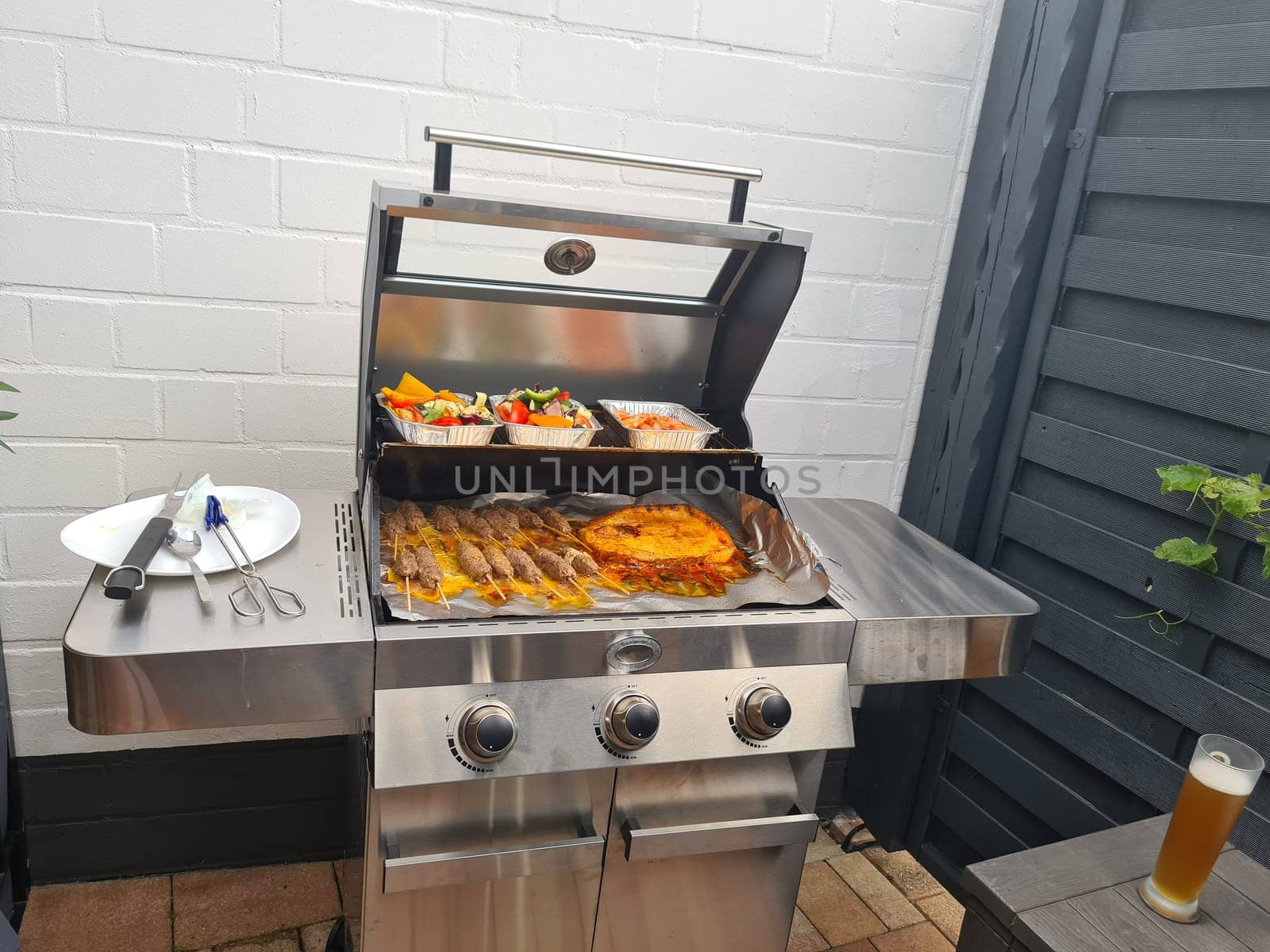 Grilled skewers with mixed vegetables served on a wooden cutting board with a vegan herb dip