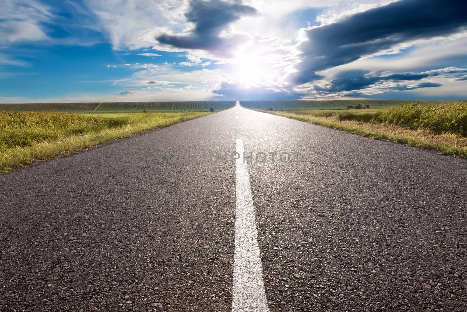 Driving on an empty road to the sun