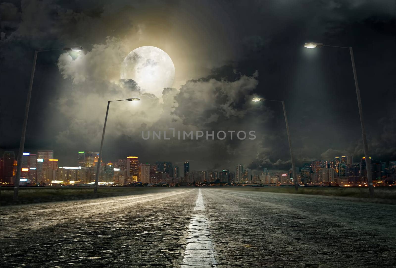 asphalt road leading into the city at night