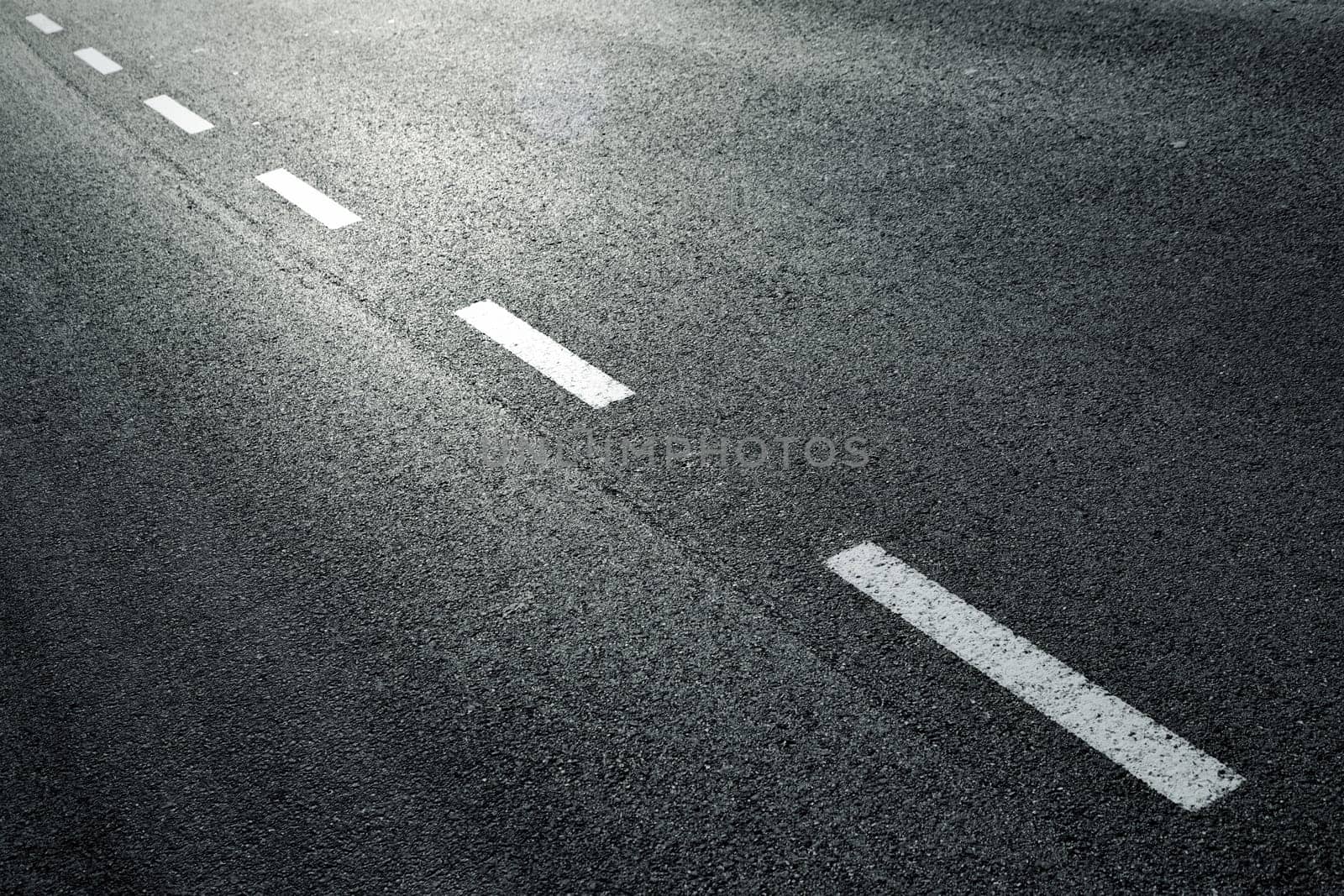 White dotted line on city asphalt road background.