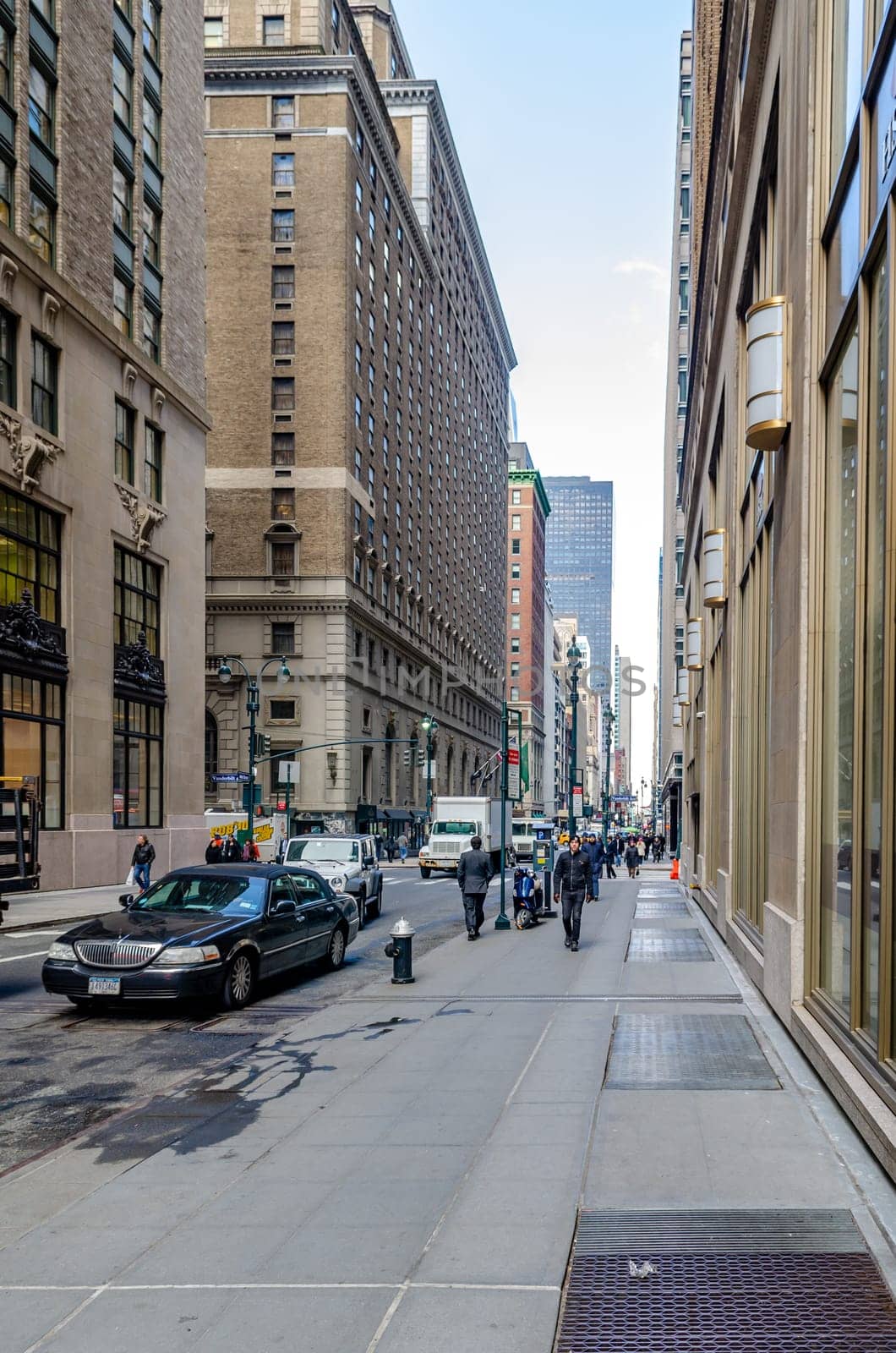 Manhattan, New York City, Side Street with Cars and People walking on Sidewalk, delivery vehicle in the background, puddle in the forefront, vertical