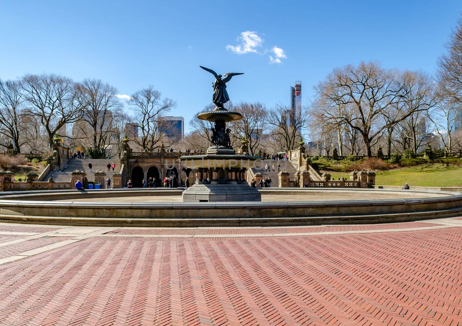 Bethesda Fountain with Angel of the Waters Sculpture rear view, Central Park New York during winter with clear sky, lots of people walking in the background, horizontal