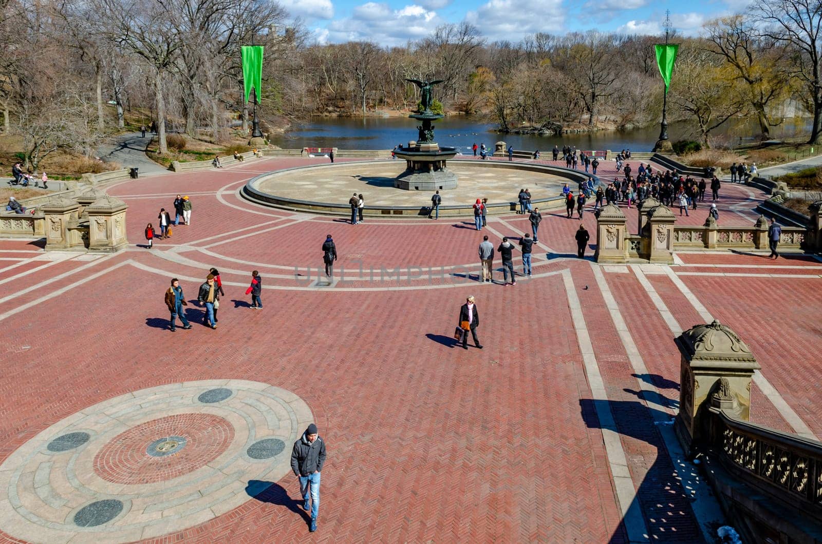 Bethesda Fountain with Angel of the Waters Sculpture wide angle shot, aerial view Central Park New York, lots of people around the fountain, lake in the background during daylight in winter, horizontal