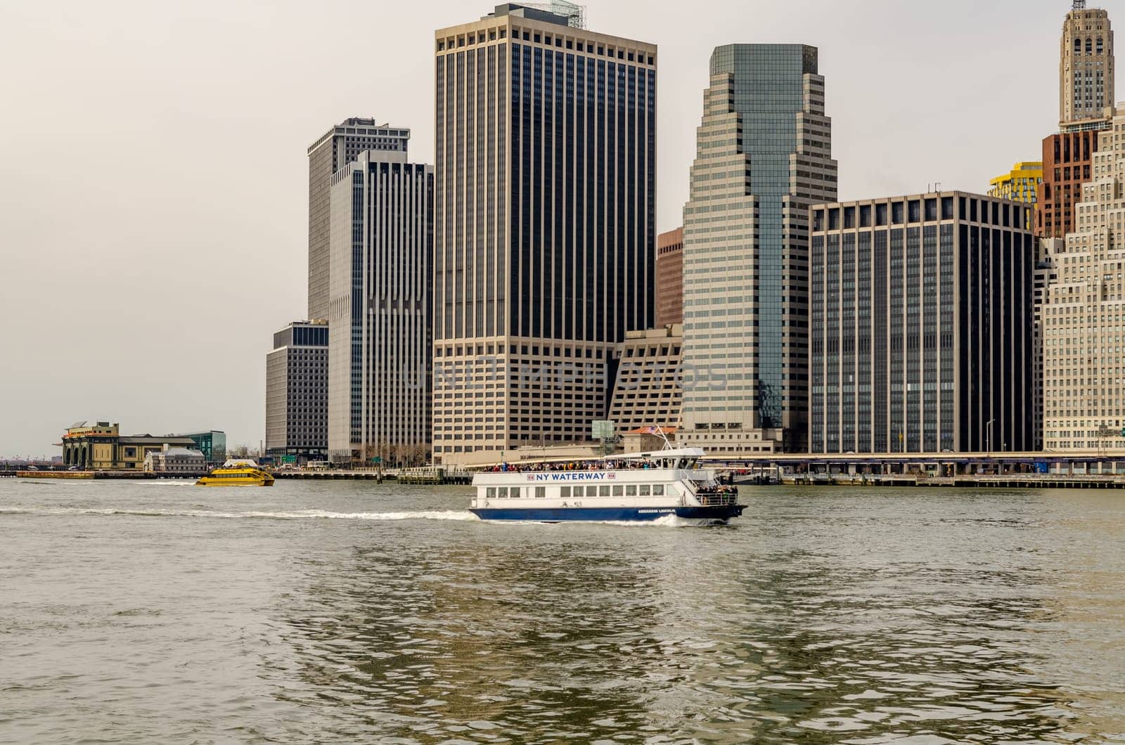 NY Waterway white Ferry in front of Skyline of Manhattan at east river in the evening, New York City, during winter, horizontal