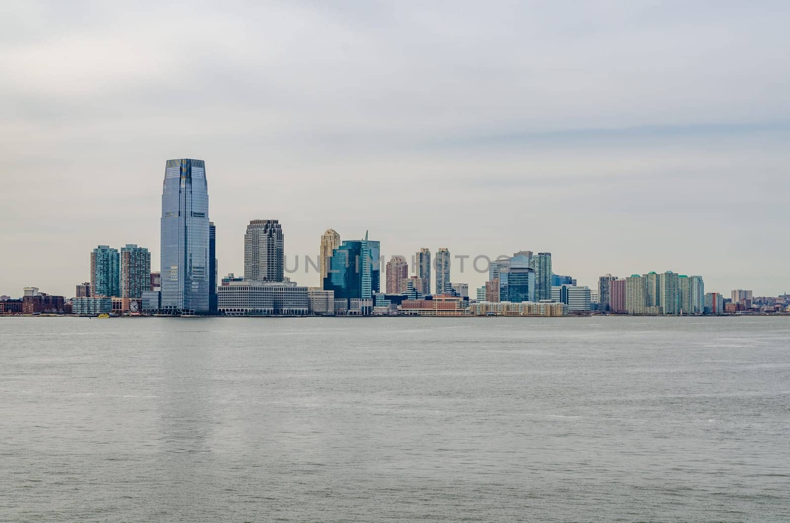 Jersey City Skyline wit lots of skyscraper office Buildings, New Jersey with Hudson river in forefront, during winter day and overcast, horizontal