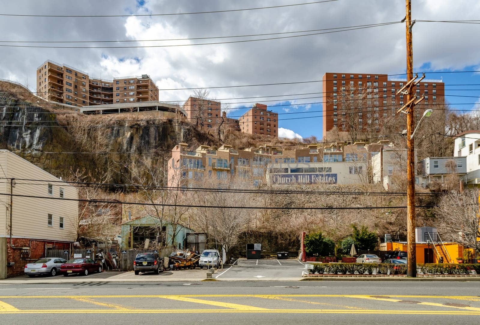 Church Hill Estates Building with residential Building Skyscraper on a rock on top of the hill, North Bergen, New Jersey, during a sunny winter day, road in the forefront, horizontal