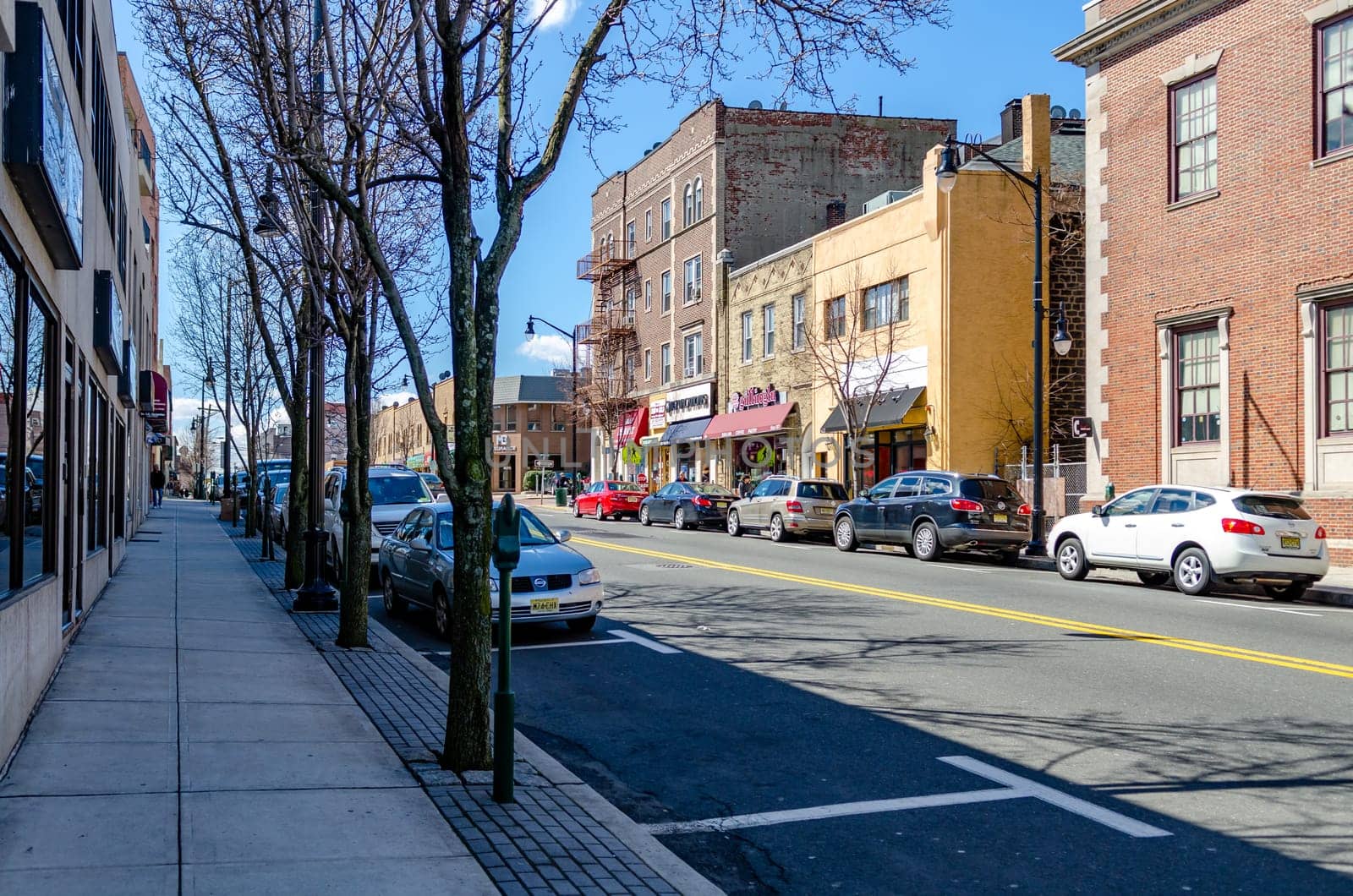 Retail Stores at Center of the City near Cliffside Park, New Jersey, during a sunny winter day, Cars are parked in the street, two free parking lot in front, horizontal